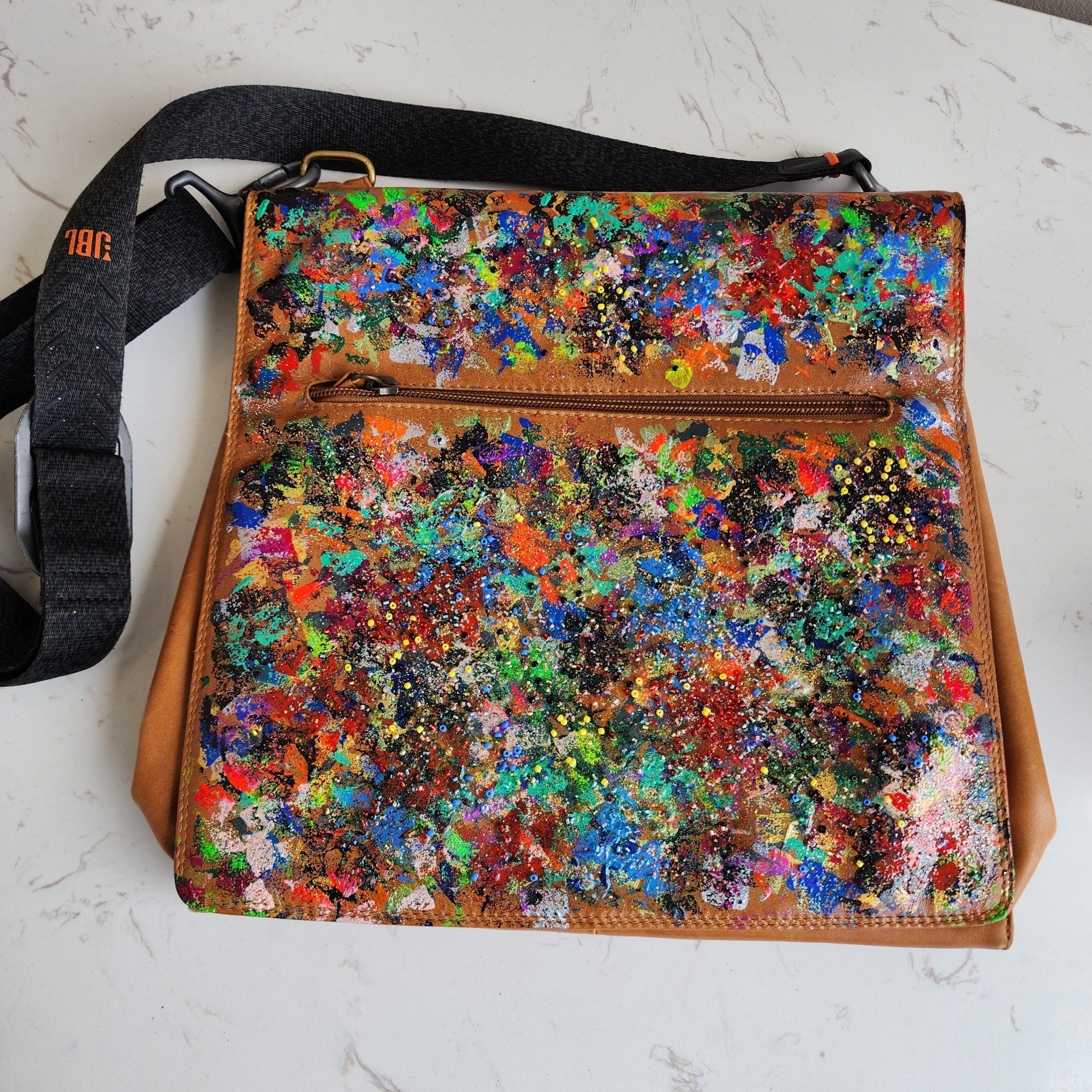 Mixed media leather messenger bag painted by Vaughn Lowery in Phnom Penh via 360 MAGAZINE. 